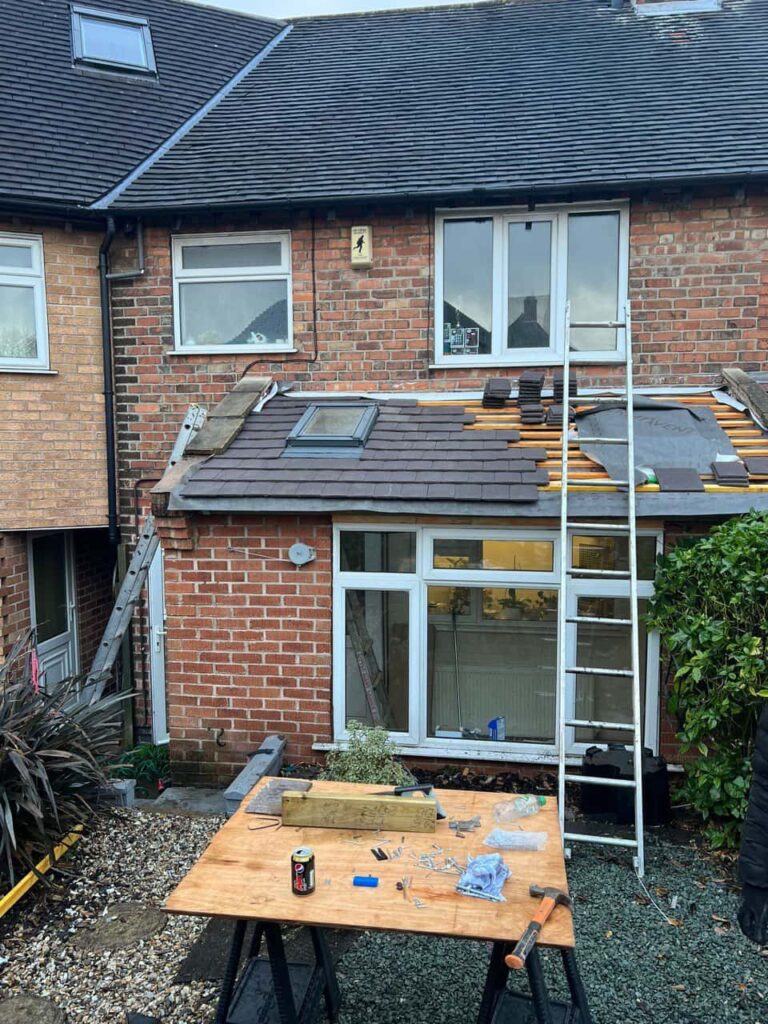 This is a photo of a roof extension that is having new roof tiles installed. This is a photo taken from the roof ridge looking down a tiled pitched roof on to a flat roof. Works carried out by Hinckley Roofing Repairs