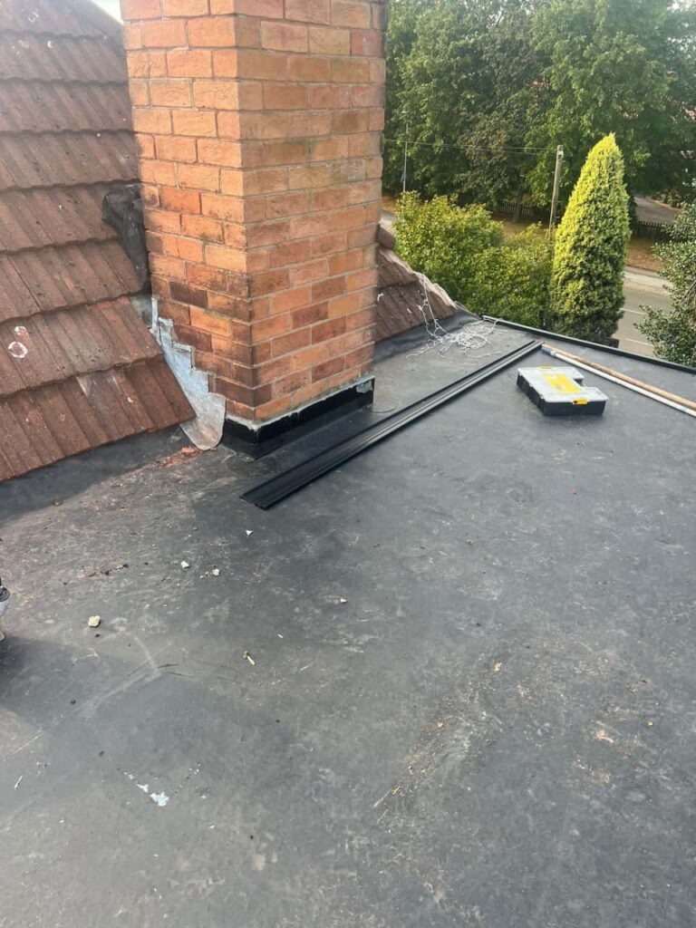 This is a photo of a flat roof which has just been repaired, there is also a chimney stack and some leadwork has also been dressed. Works carried out by Hinckley Roofing Repairs