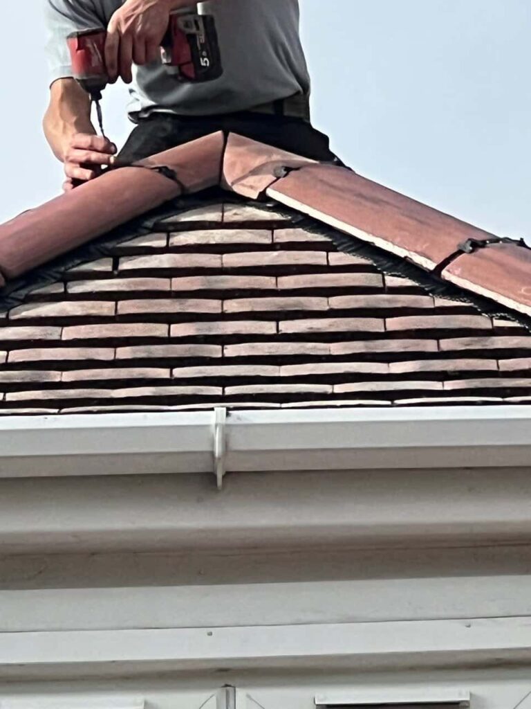 This is a photo of one of the operatives of Hinckley Roofing Repairs installing new ridge tiles